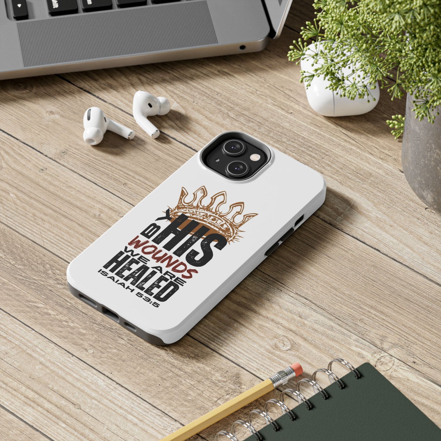 Logos Co. Christian tough phone case with inspirational Isaiah 53:5 scripture design on a wooden desk