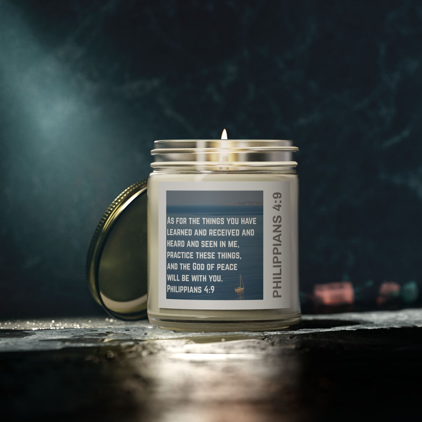 Lit eco-friendly Christian candle in glass jar with Philippians 4:9 scripture label by Logos