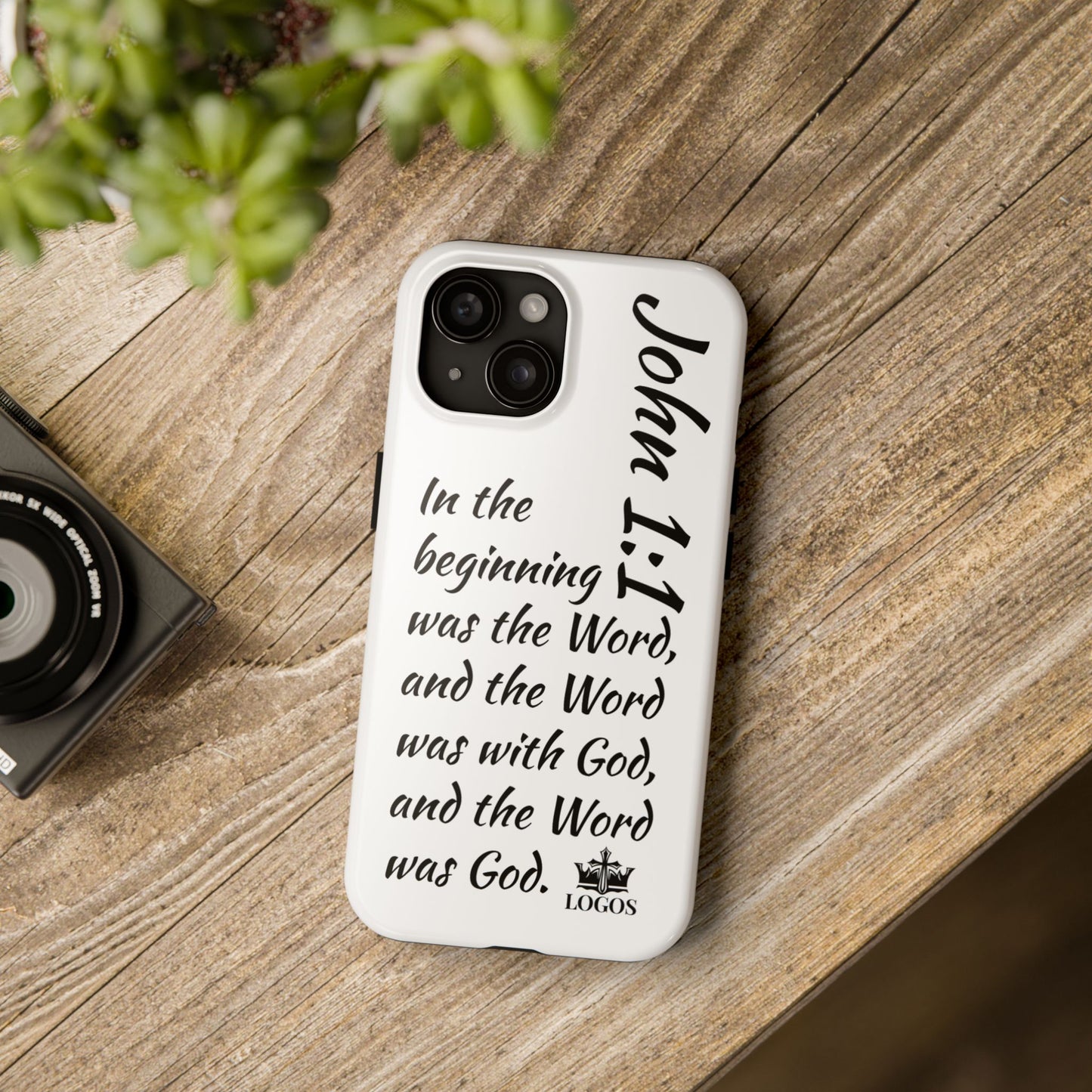 Faith-based tough phone case featuring John 1:1 verse on a wooden table backdrop