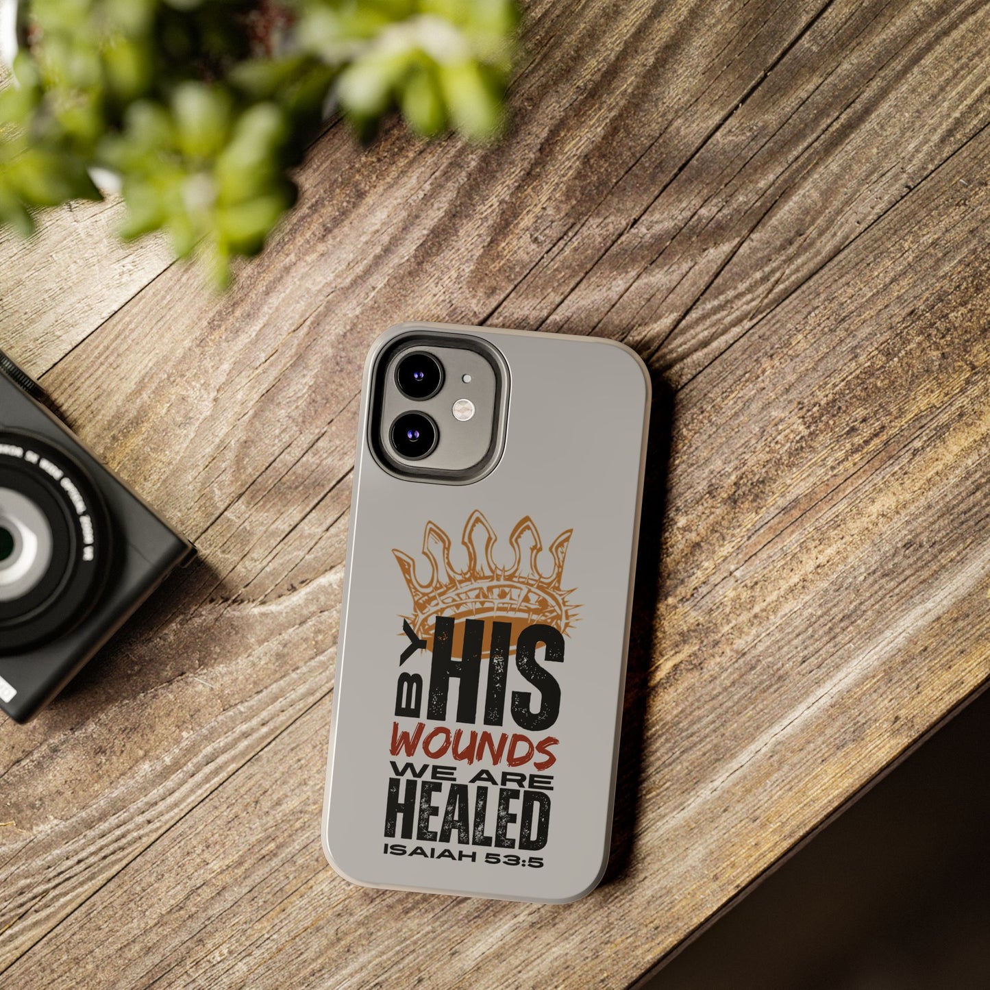 Logos gray scripture phone cover with crown and Isaiah 53:5 verse on wooden table