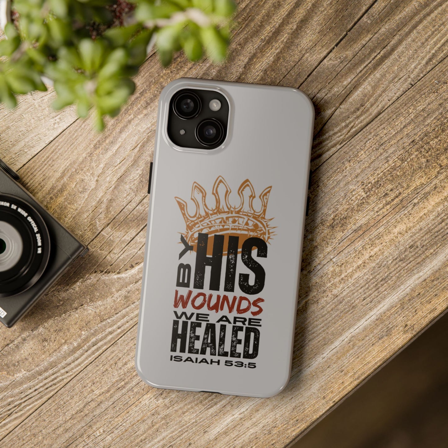 Logos gray scripture phone cover with Isaiah 53:5 Bible verse and crown design on wooden surface