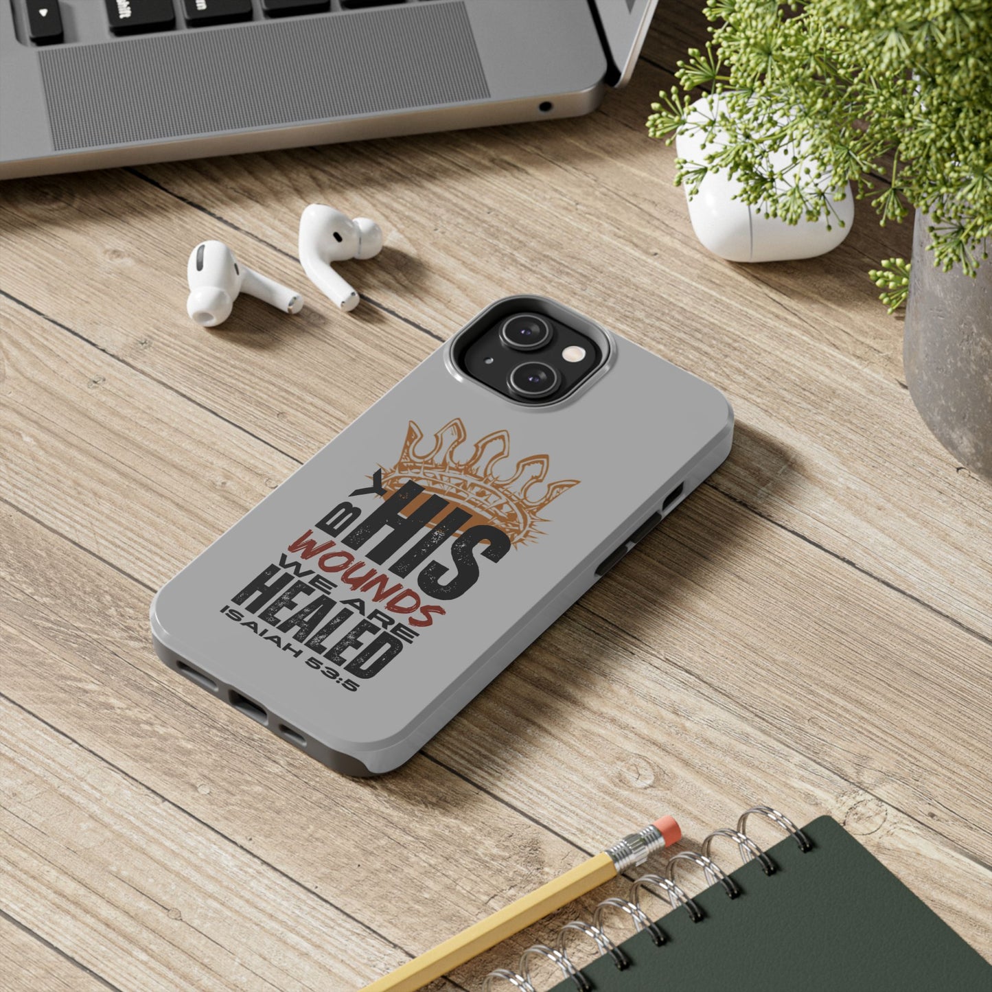 Logos gray scripture phone cover with crown and inspirational Bible verse on wooden desk