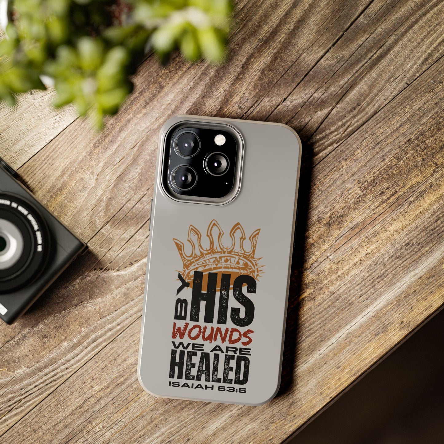 Logos Co. gray scripture phone cover with Isaiah 53:5 design and crown on wood surface