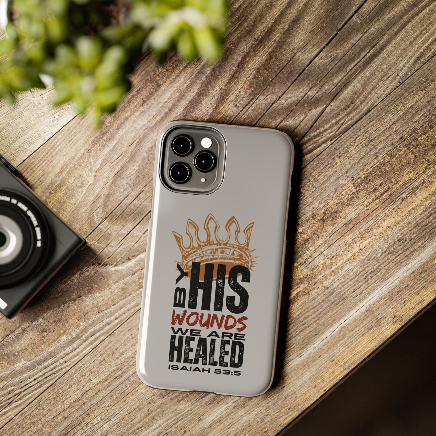 Logos gray scripture phone cover with Isaiah 53:5 quote and crown design on wooden surface