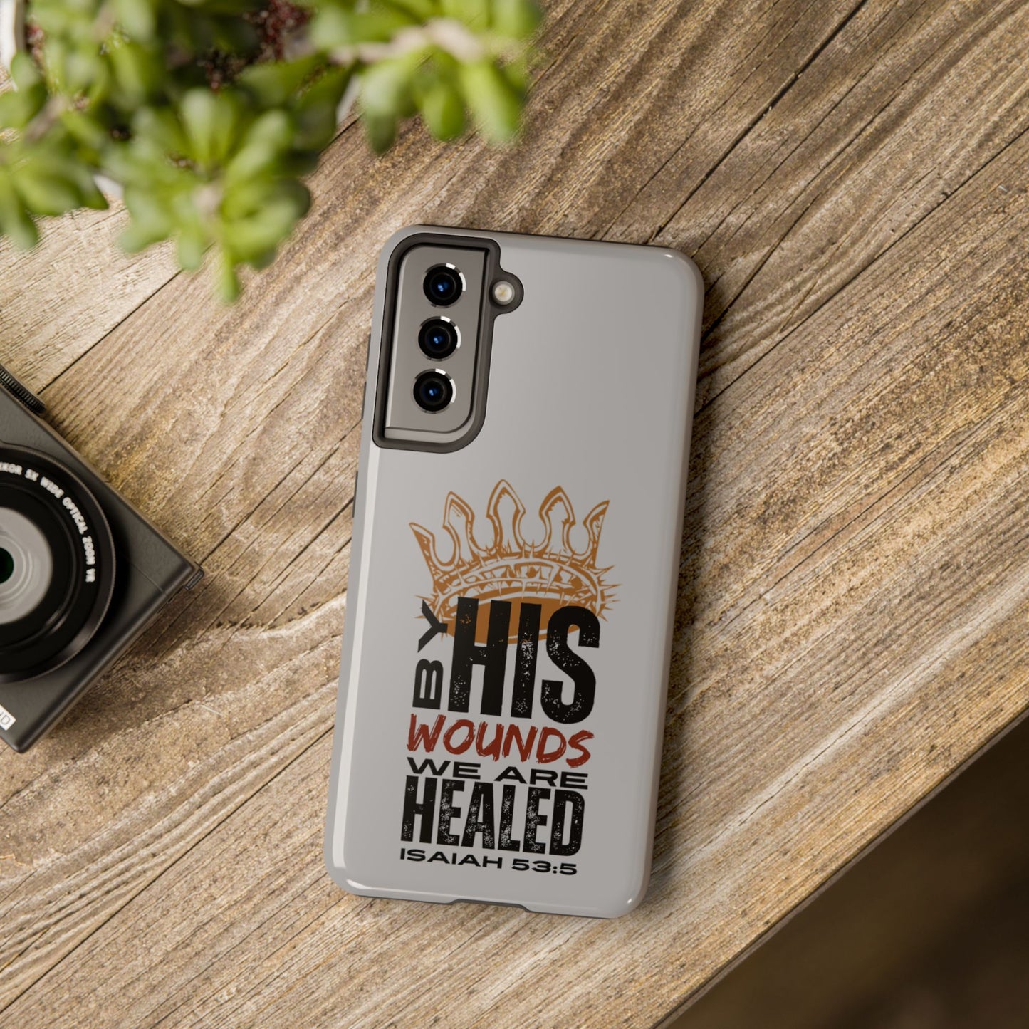Logos gray scripture phone cover with Isaiah 53:5 Bible verse and crown design on wooden table