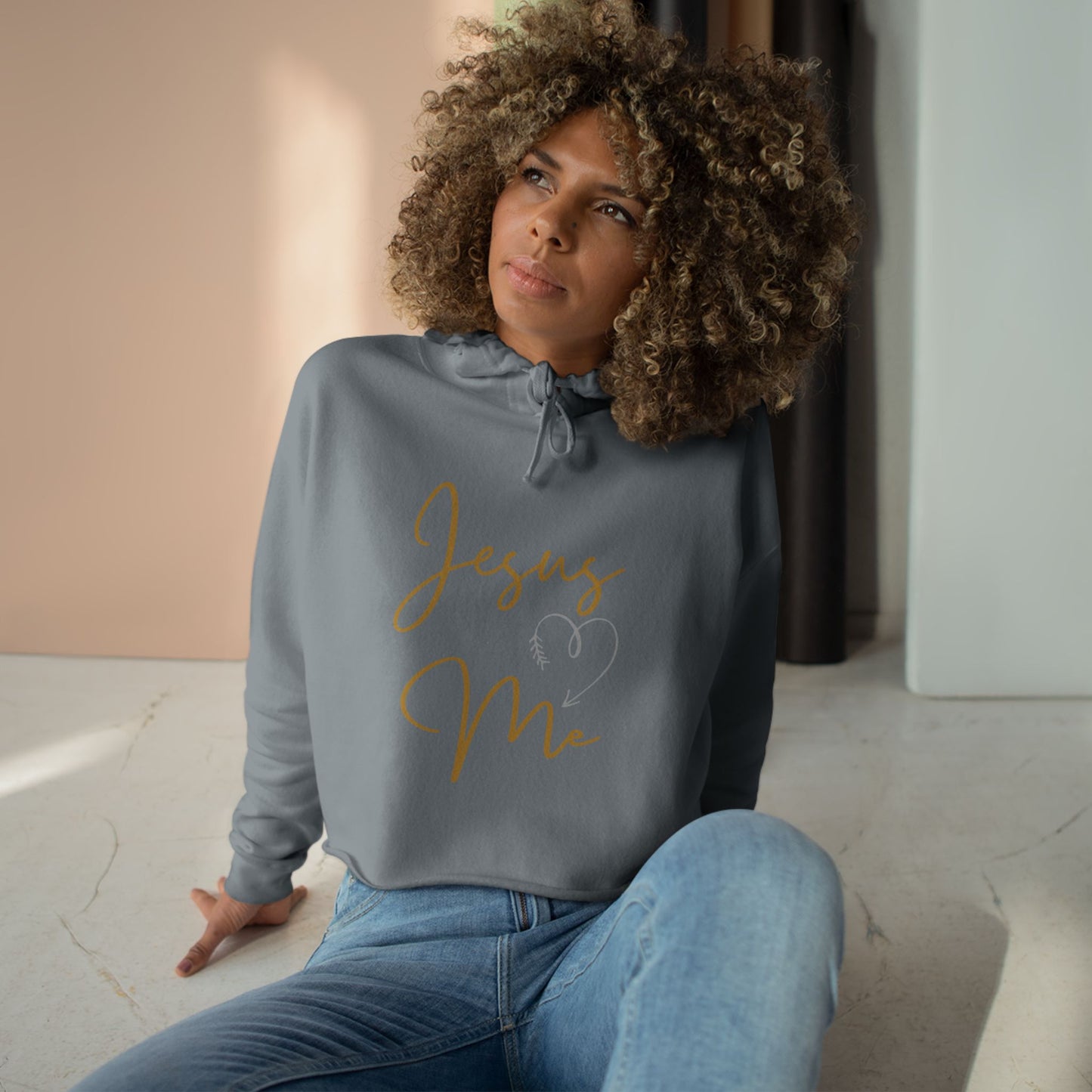 Woman wearing a gray Jesus Loves Me crop hoodie with drawstrings