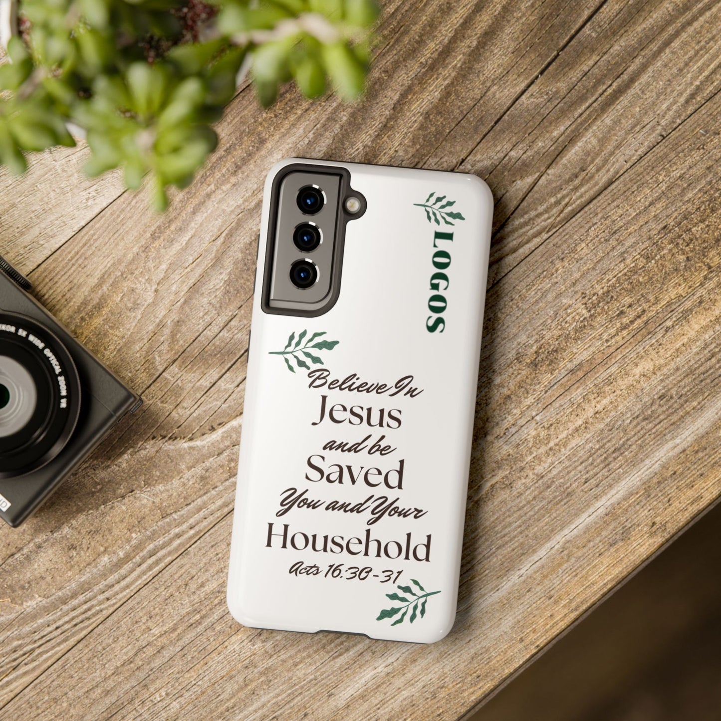 Bible verse phone case with Acts 16:30-31 scripture and leaf design by Logos on wooden surface