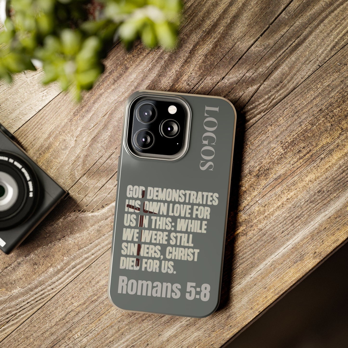 Christian phone case with Romans 5:8 scripture design on gray background for Logos