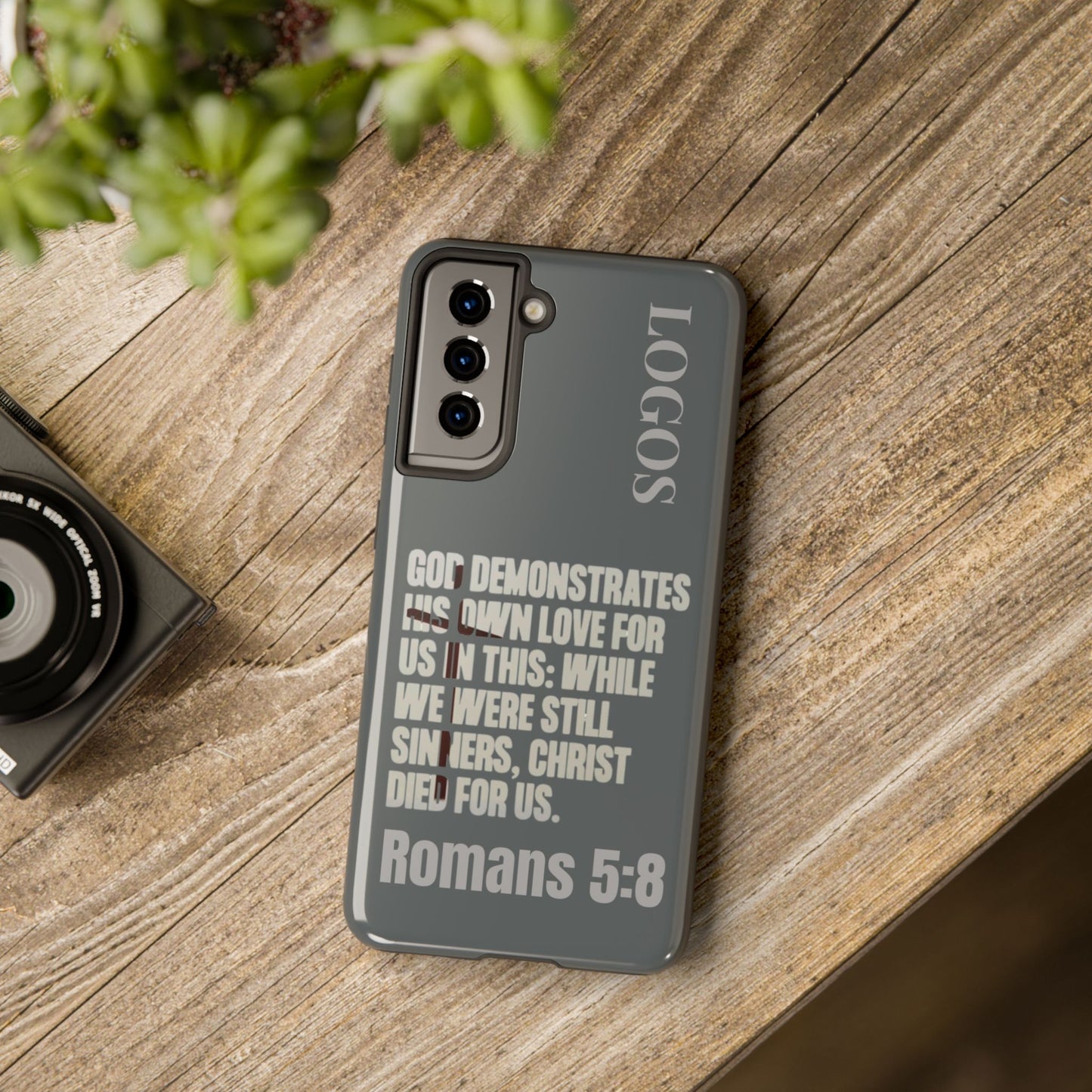 Logos Co. Christian phone case with Romans 5:8 Bible verse design on gray background for Samsung phone