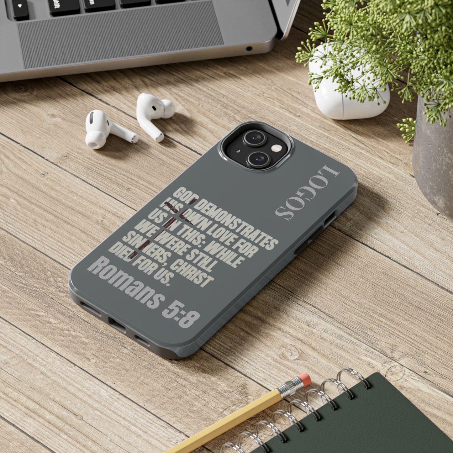 Christian phone case with Bible verse Romans 5:8 and Logos design on gray background