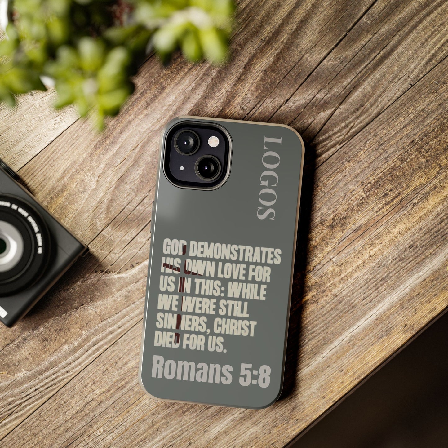 Logos Christian phone case with Romans 5:8 Bible verse quote on gray background for iPhone