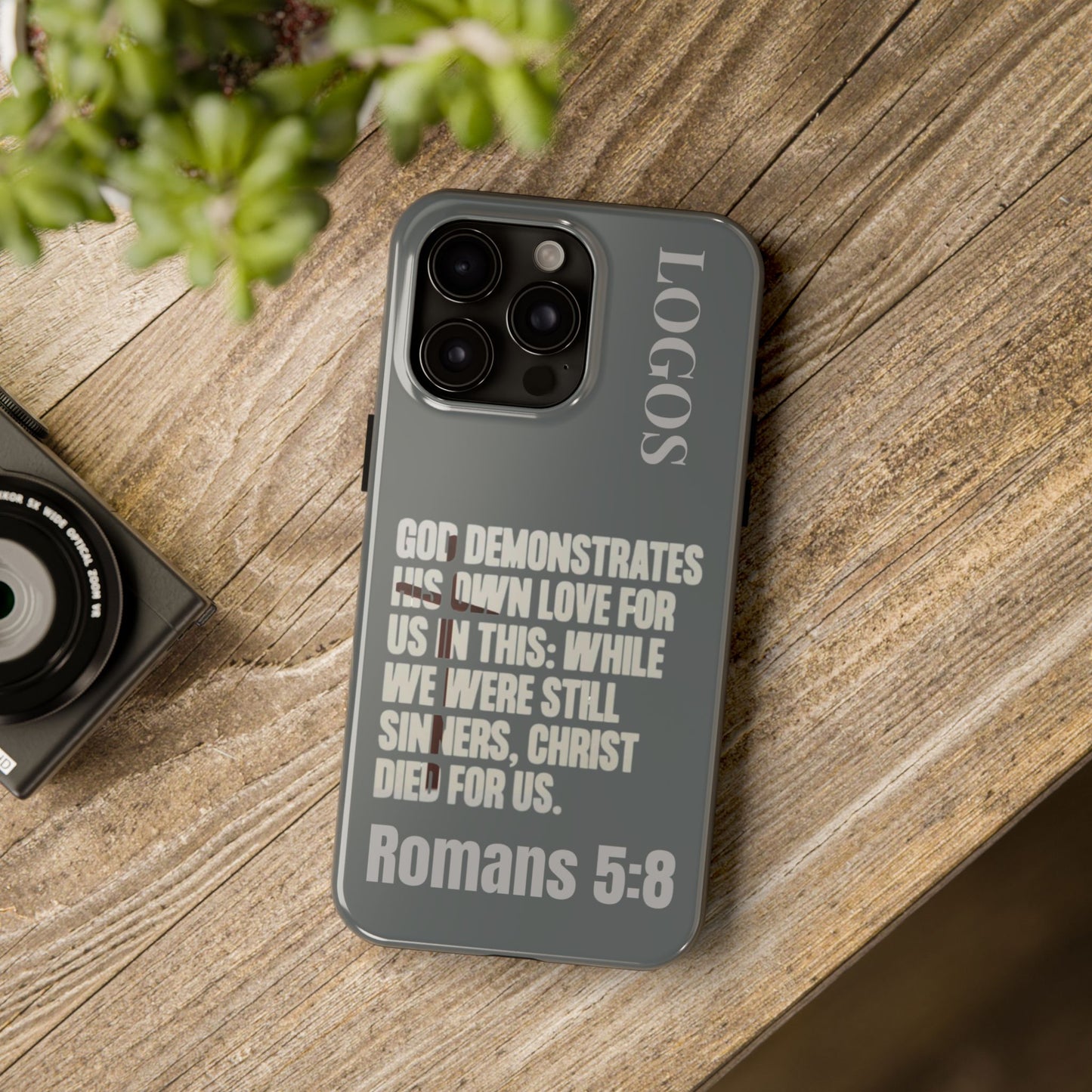 Logos Christian phone case with Bible verse Romans 5:8 on gray background for iPhone