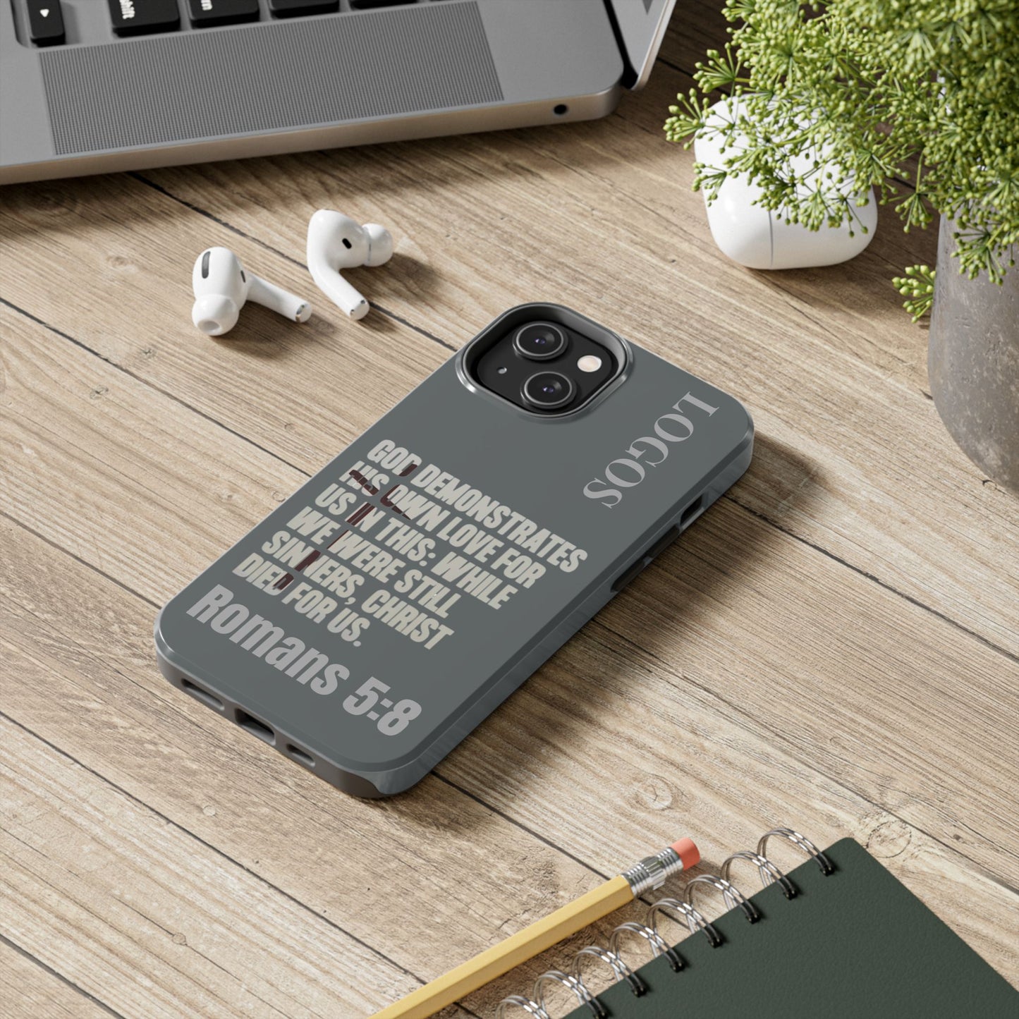 Logos Co. Gray Christian phone case with Bible verse Romans 5:8 on gray background for iPhone