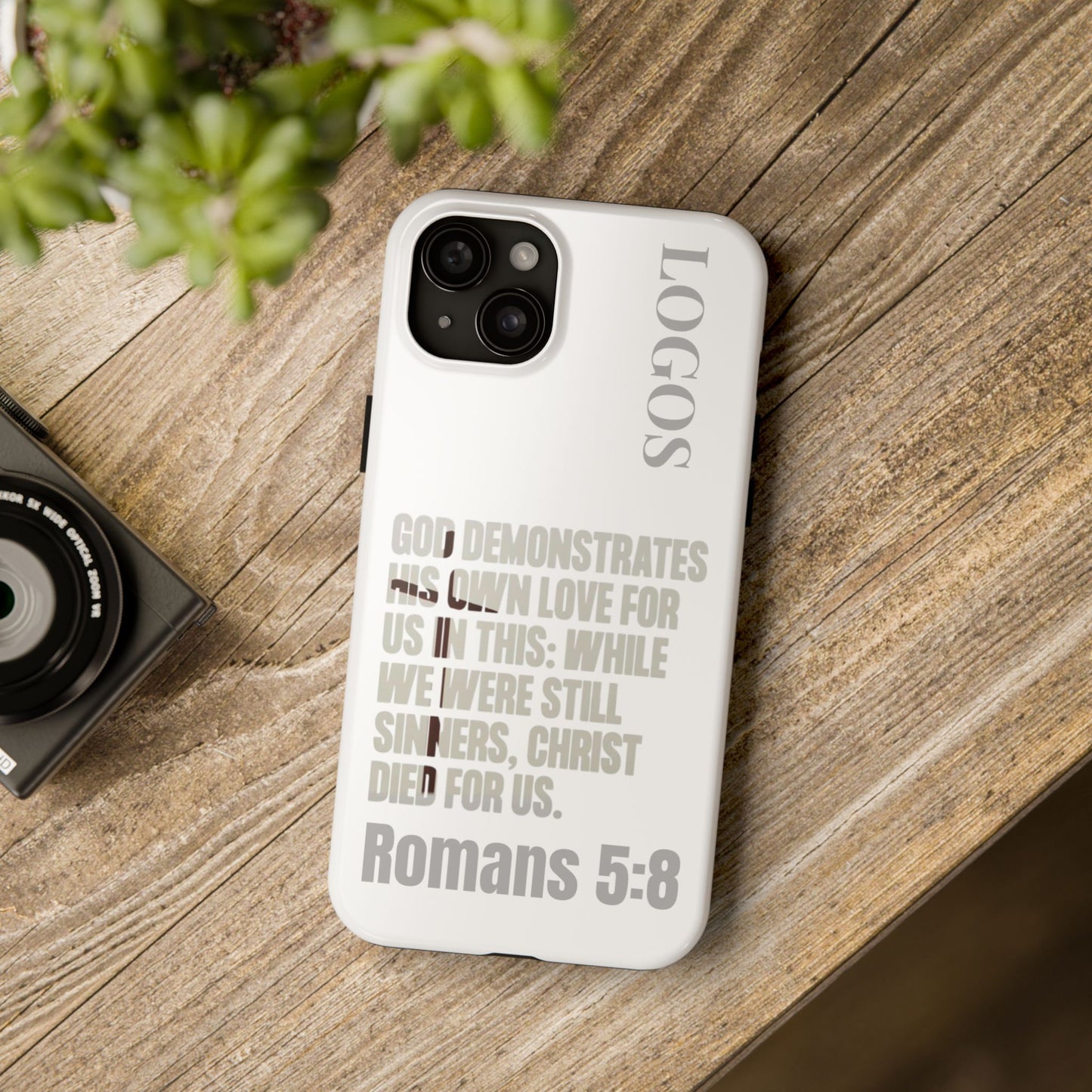 Logos Co. white phone case with Romans 5:8 faith-based tough cases scripture design on wooden surface
