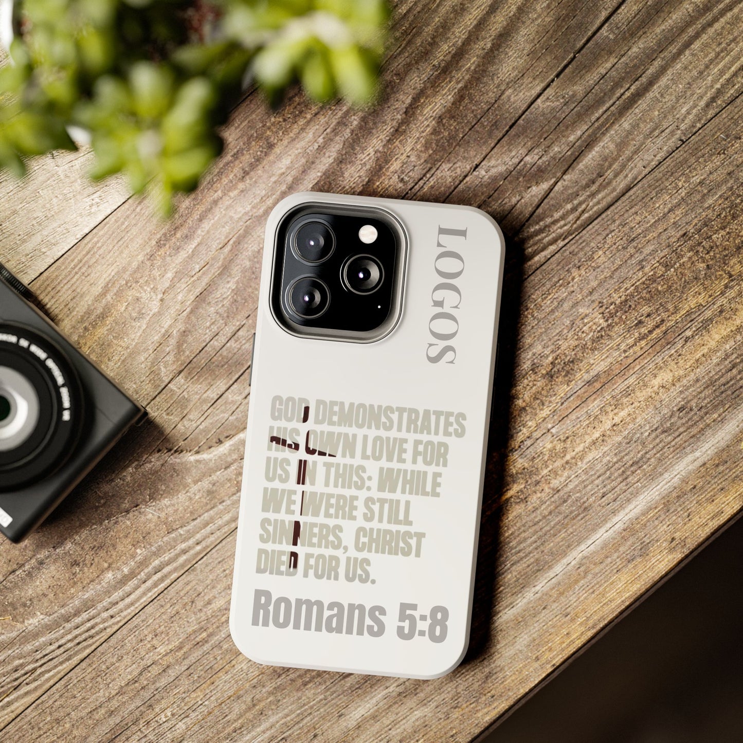Logos Co. faith-based tough cases phone case with Romans 5:8 Bible verse design on wooden surface
