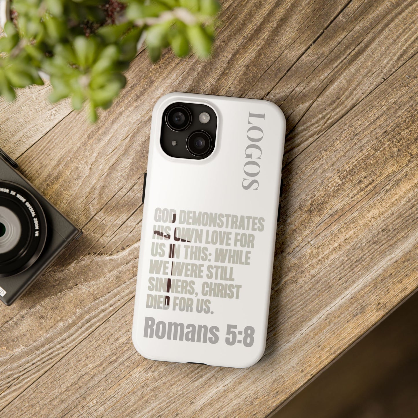 Logos Co. faith-based tough cases white phone case with Romans 5:8 scripture text on wooden table