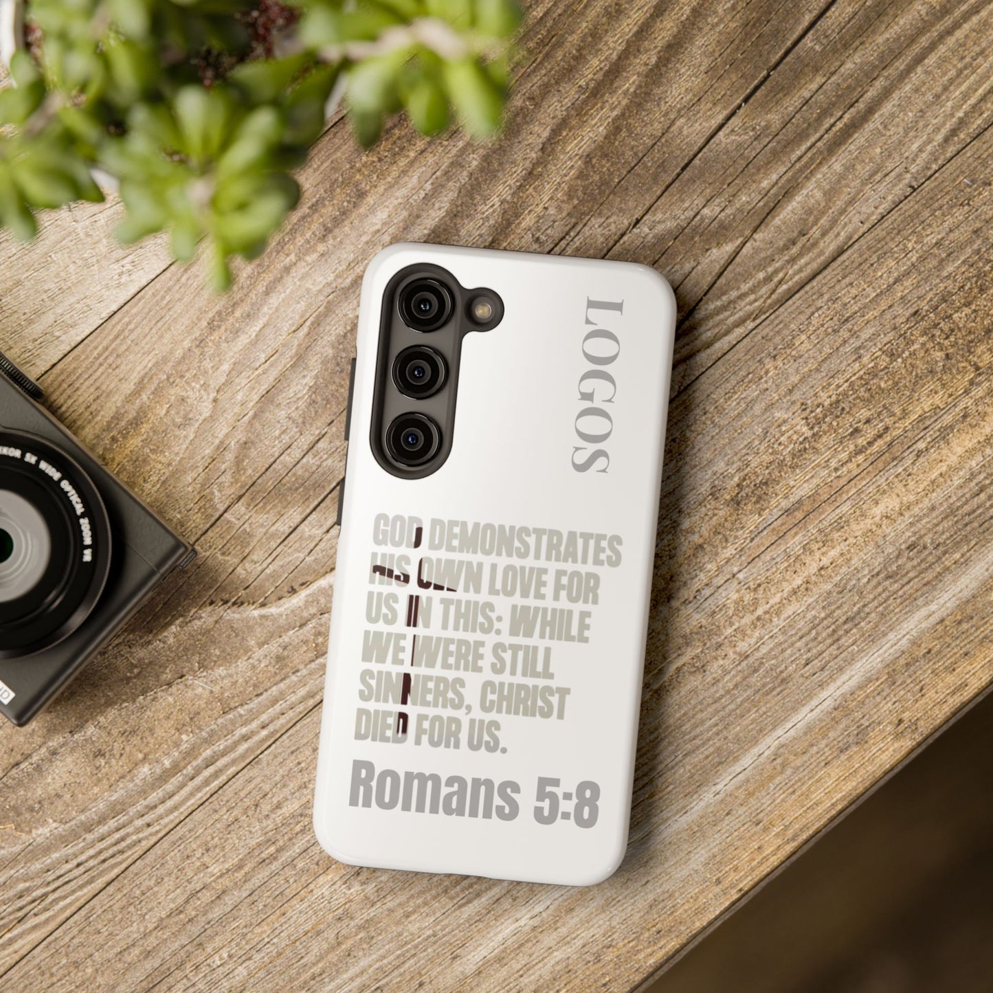 Logos Co. faith-based tough cases white phone case with Romans 5:8 scripture design on wooden table