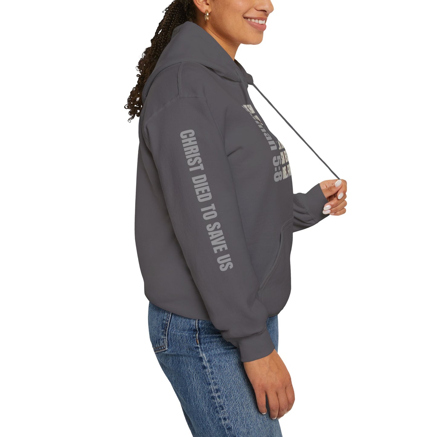 Romans 5:8 hoodie in charcoal worn by woman showing side text Christ died to save us