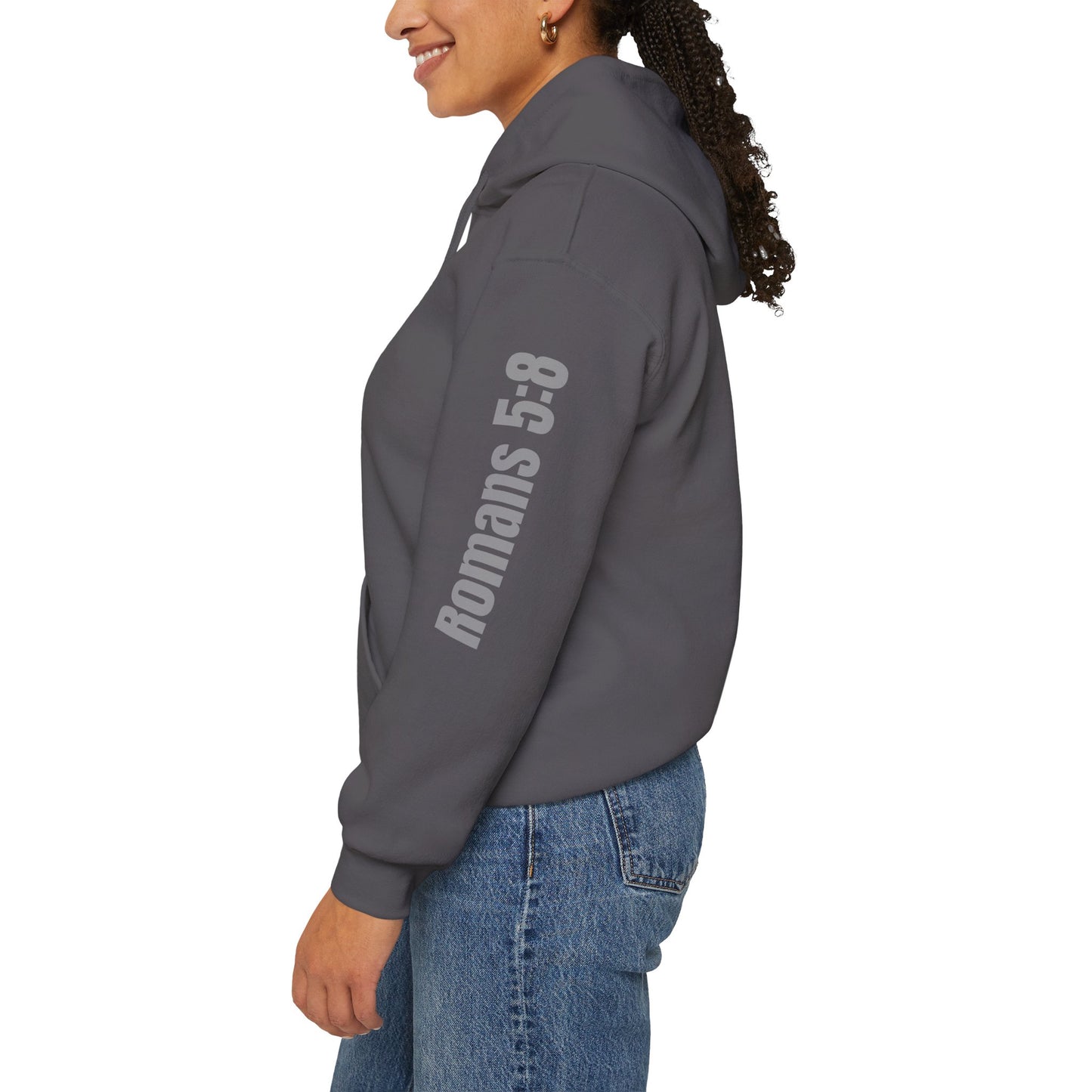 Romans 5:8 hoodie in charcoal worn by woman showing sleeve text design