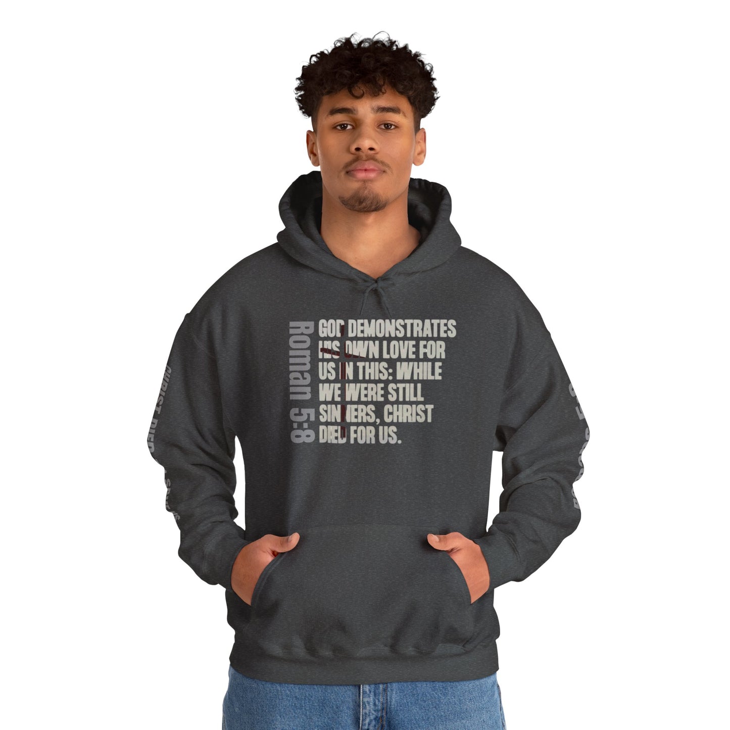 Romans 5:8 hoodie in dark heather with scripture text design worn by a man