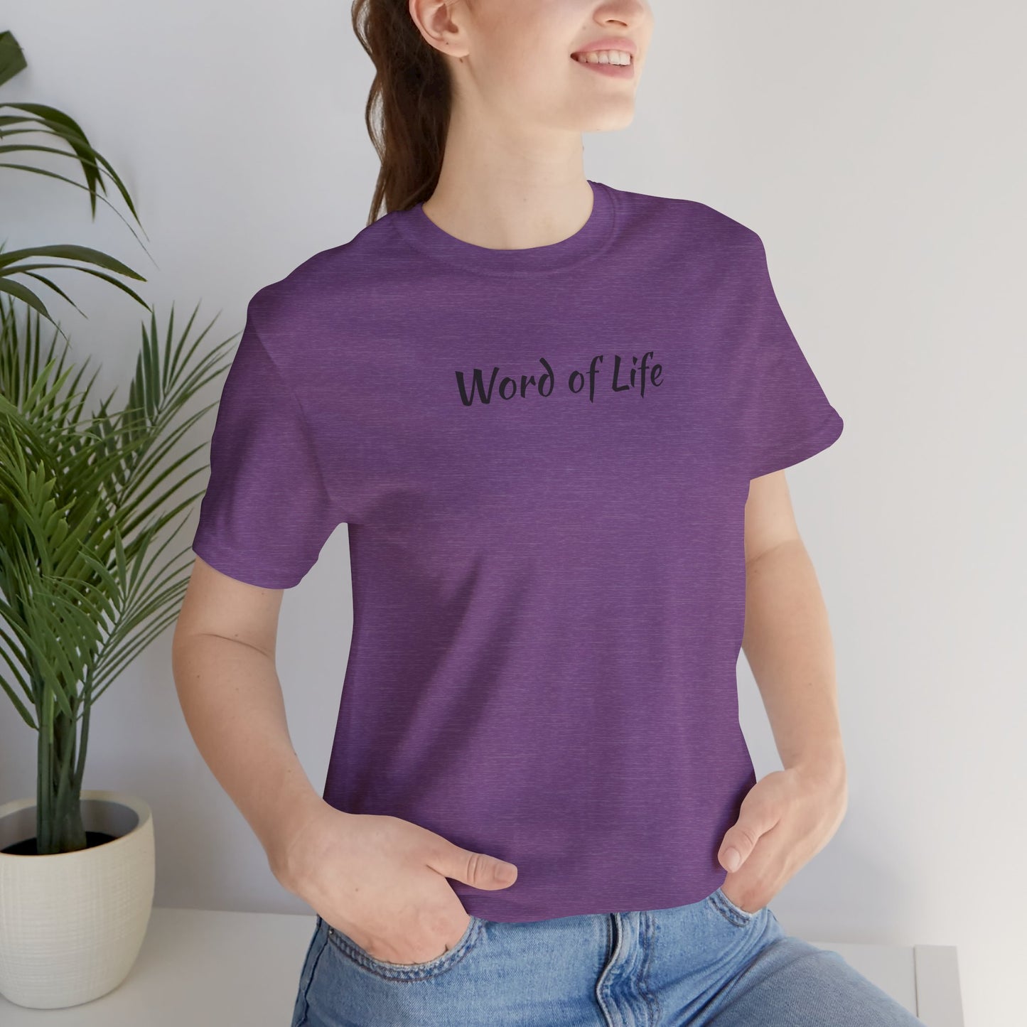 Purple Word of Life Christian shirt by Logos worn by woman with hands in pockets