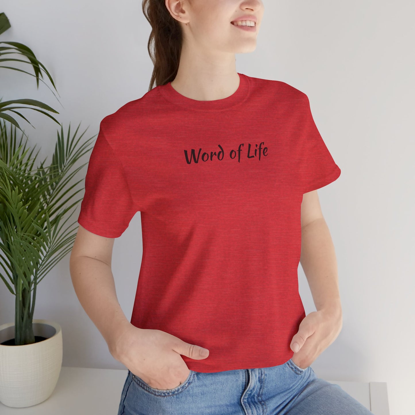 Red Word of Life Christian shirt by Logos worn by a woman with hands in pockets