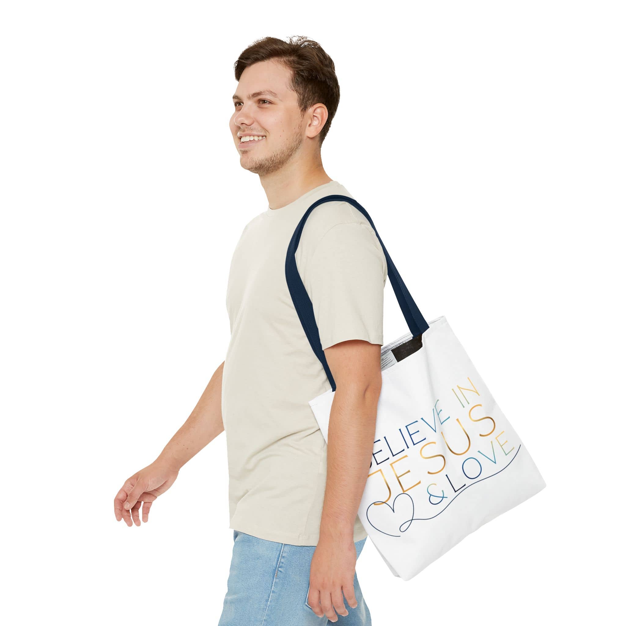 Believe in Jesus & Love Tote Bag in white with colorful text, displayed on a person from the front