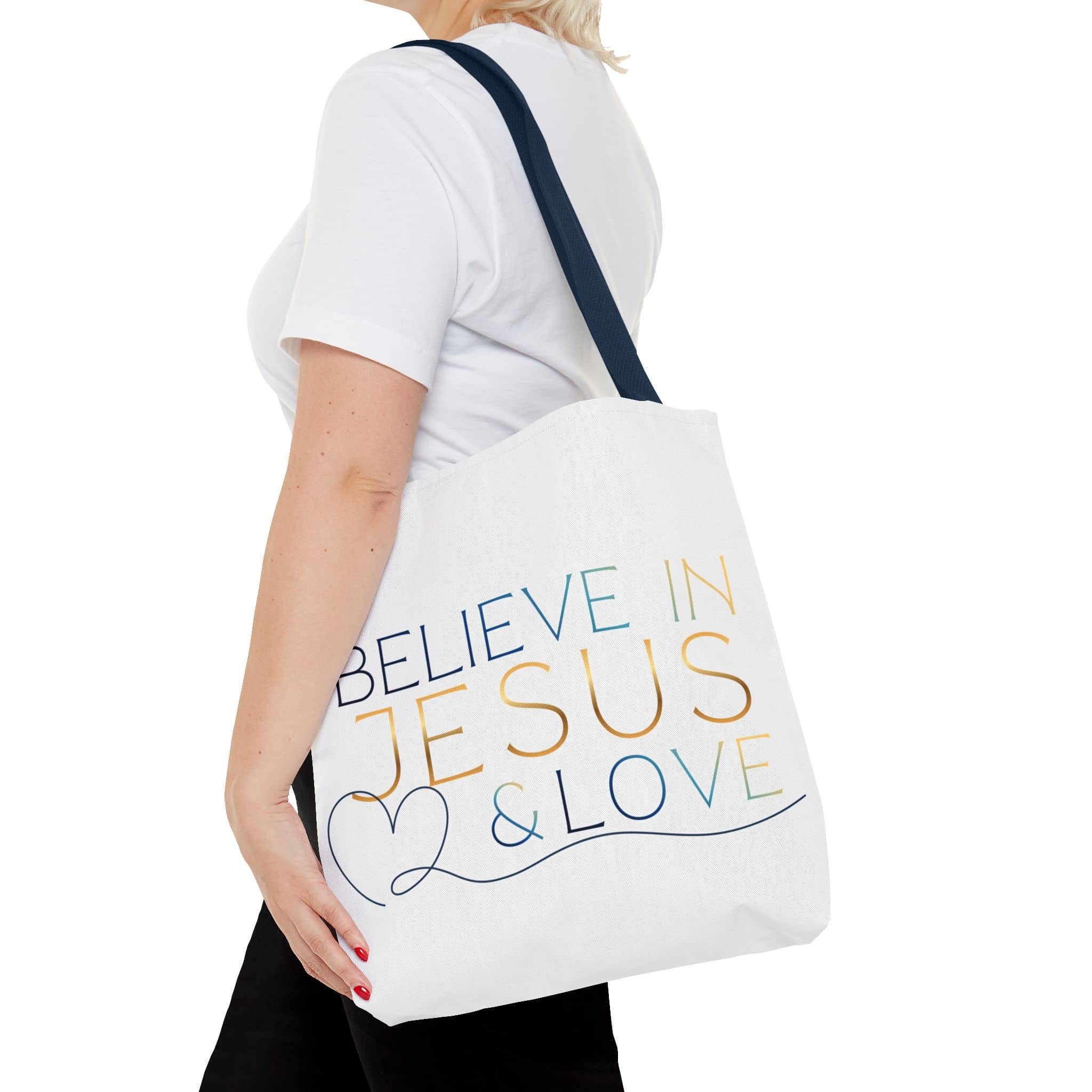 Tote bag with 'Believe in Jesus & Love' design in colorful text, shown from the side on a model