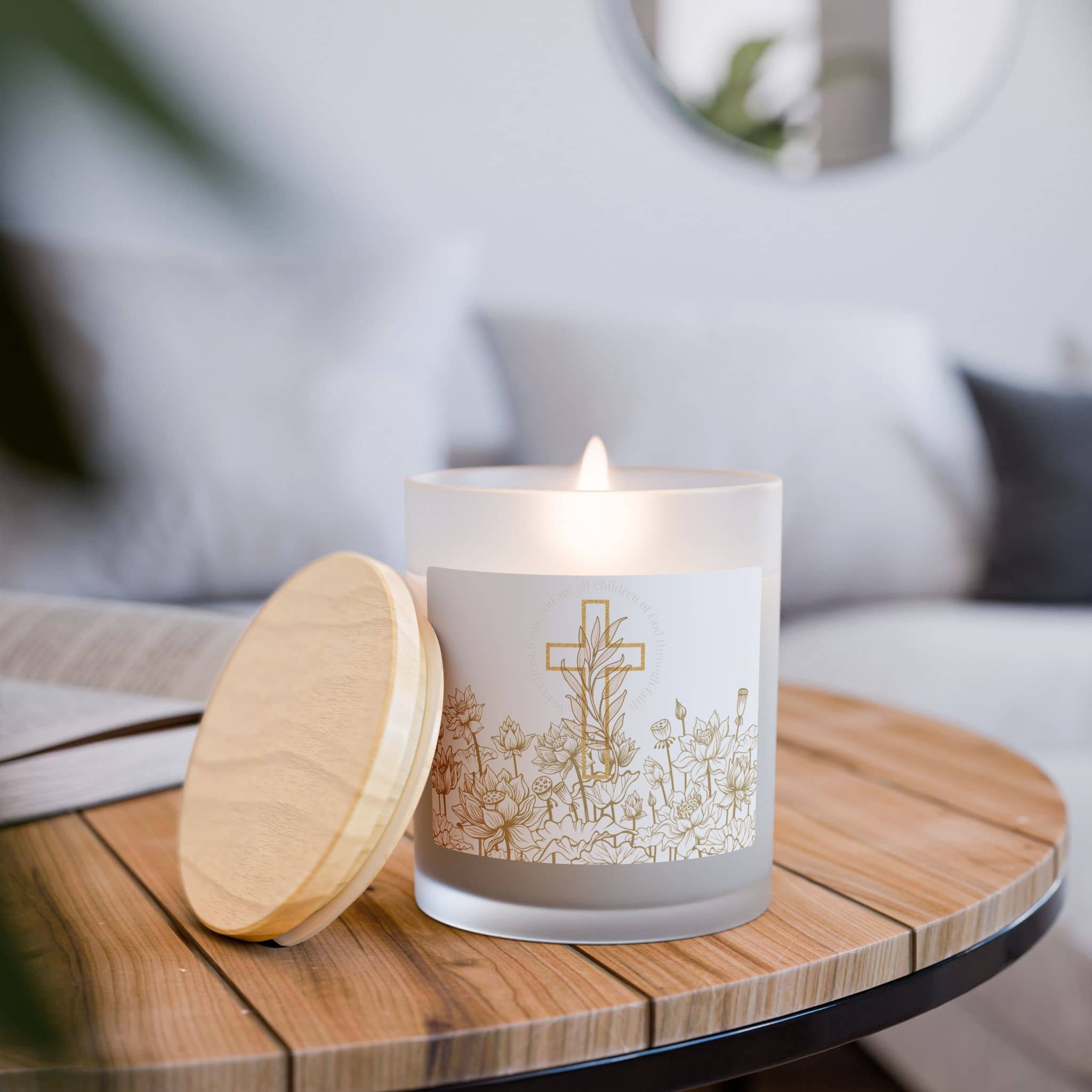 Children of God Candle with floral design and wooden lid, displayed on a wooden table in a cozy living room