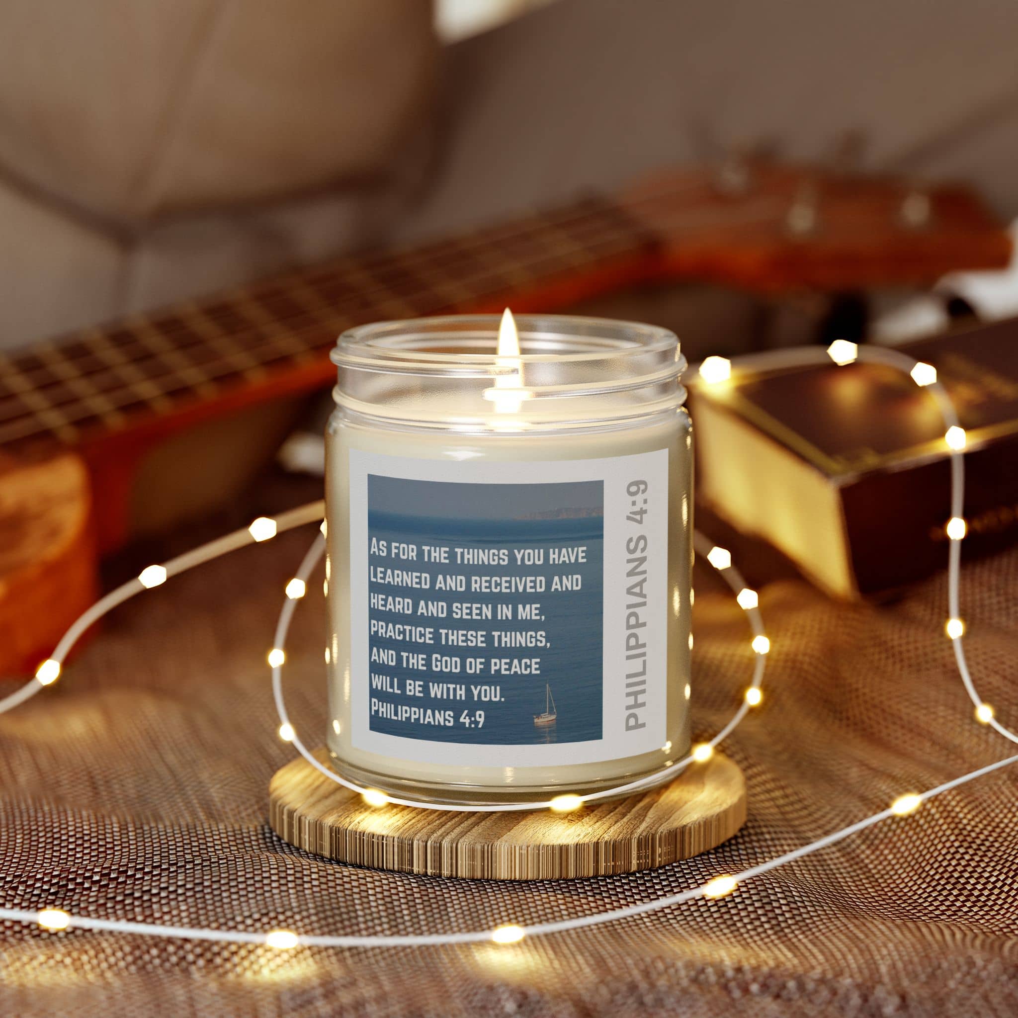 Eco-friendly Christian candle with Philippians 4:9 scripture and warm glowing flame on wooden coaster