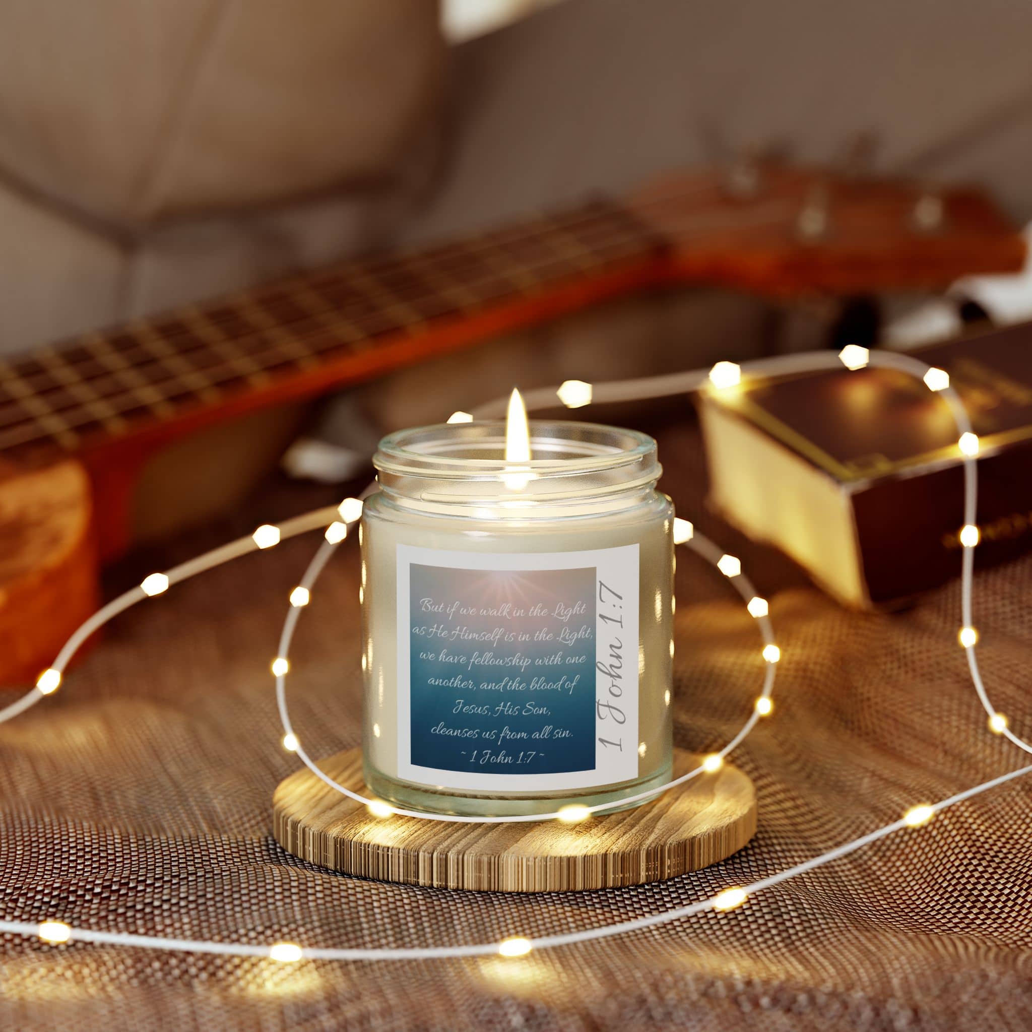 Eco-friendly scripture candle with uplifting message on a wooden coaster, surrounded by fairy lights