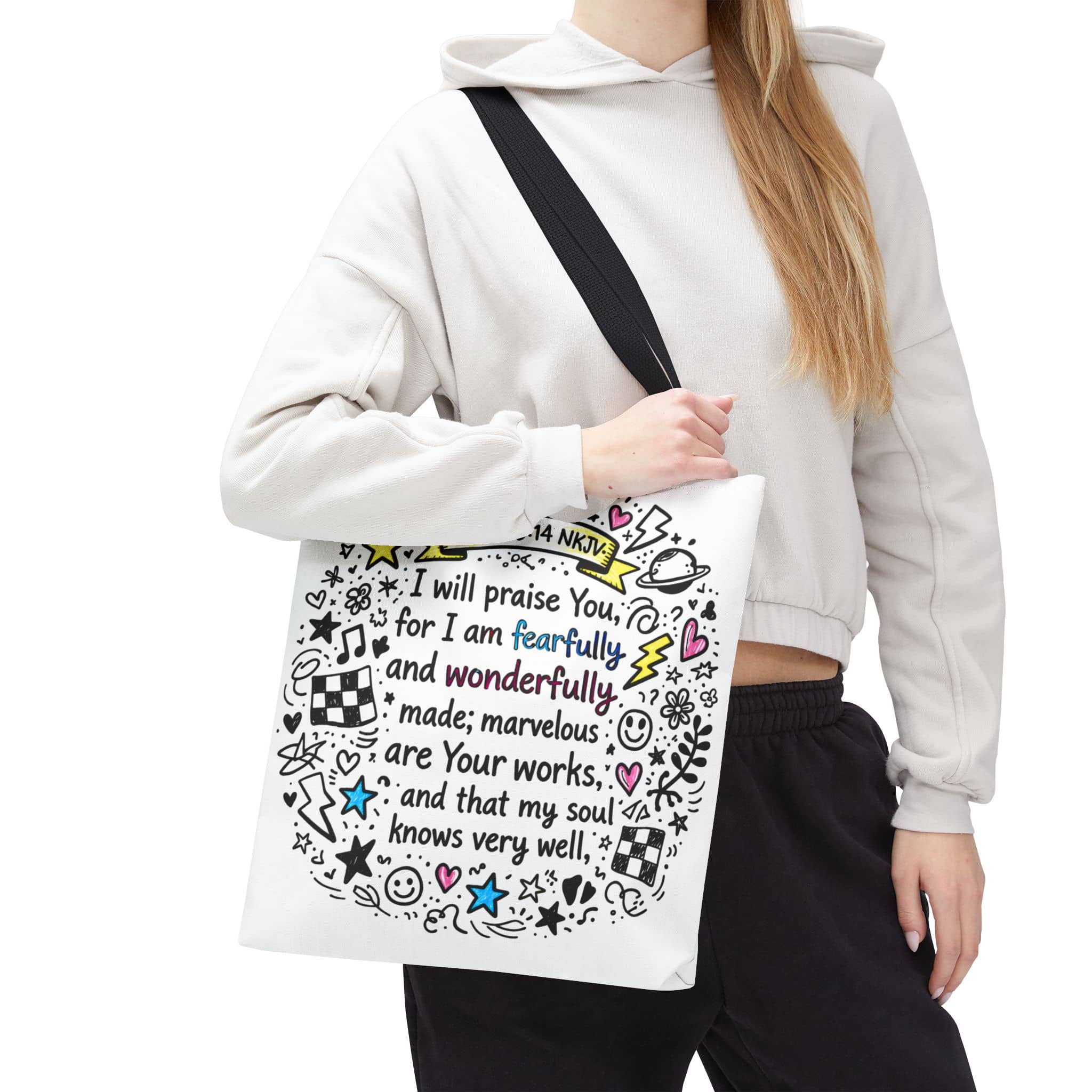 Canvas tote bag featuring 'Fearfully and Wonderfully Made' design in colorful print, held in front by model