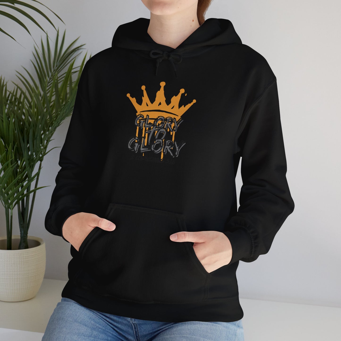 Black Glory to Glory hoodie with orange crown graphic and front pocket worn by person indoors