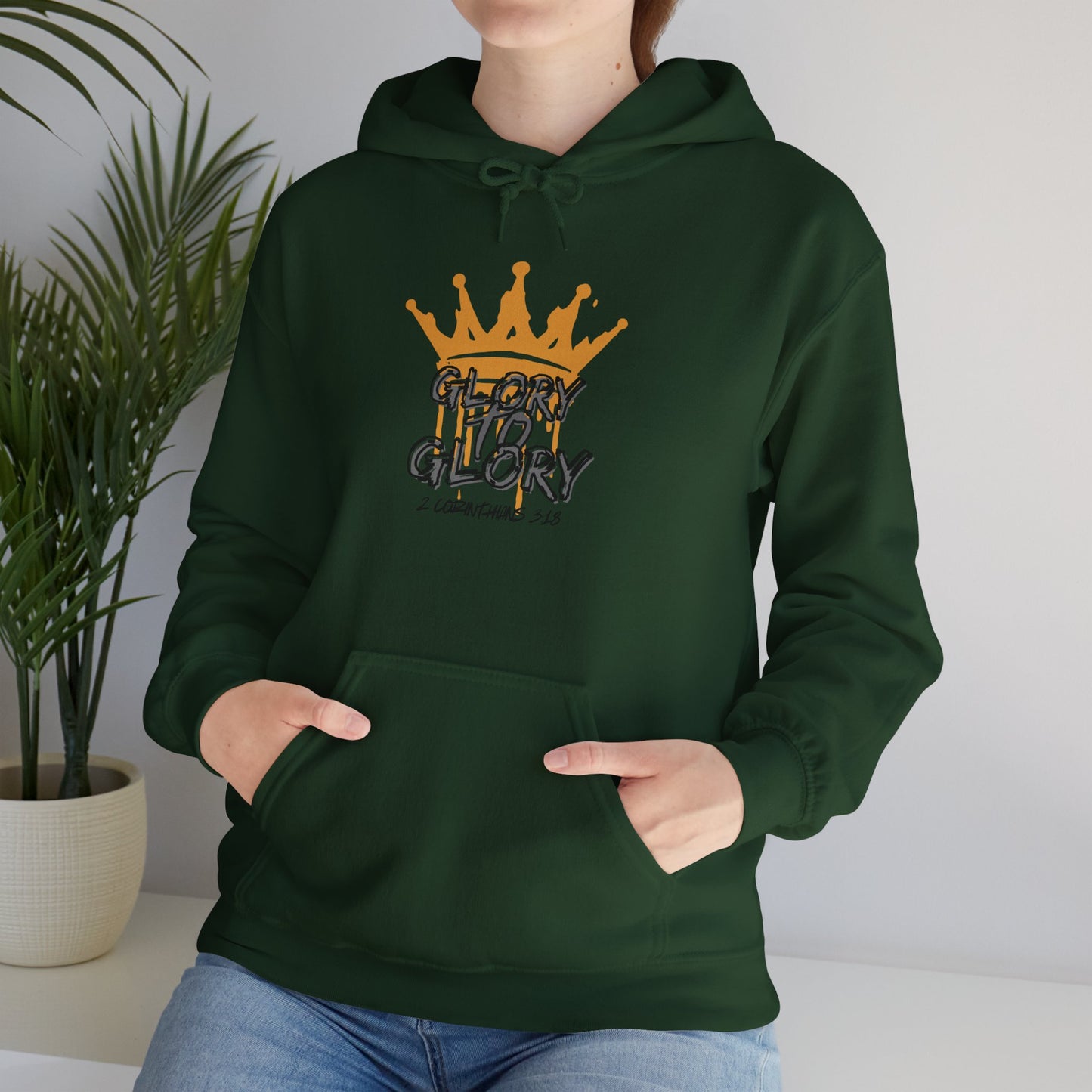 Forest green Glory to Glory hoodie with crown graphic worn by a woman indoors