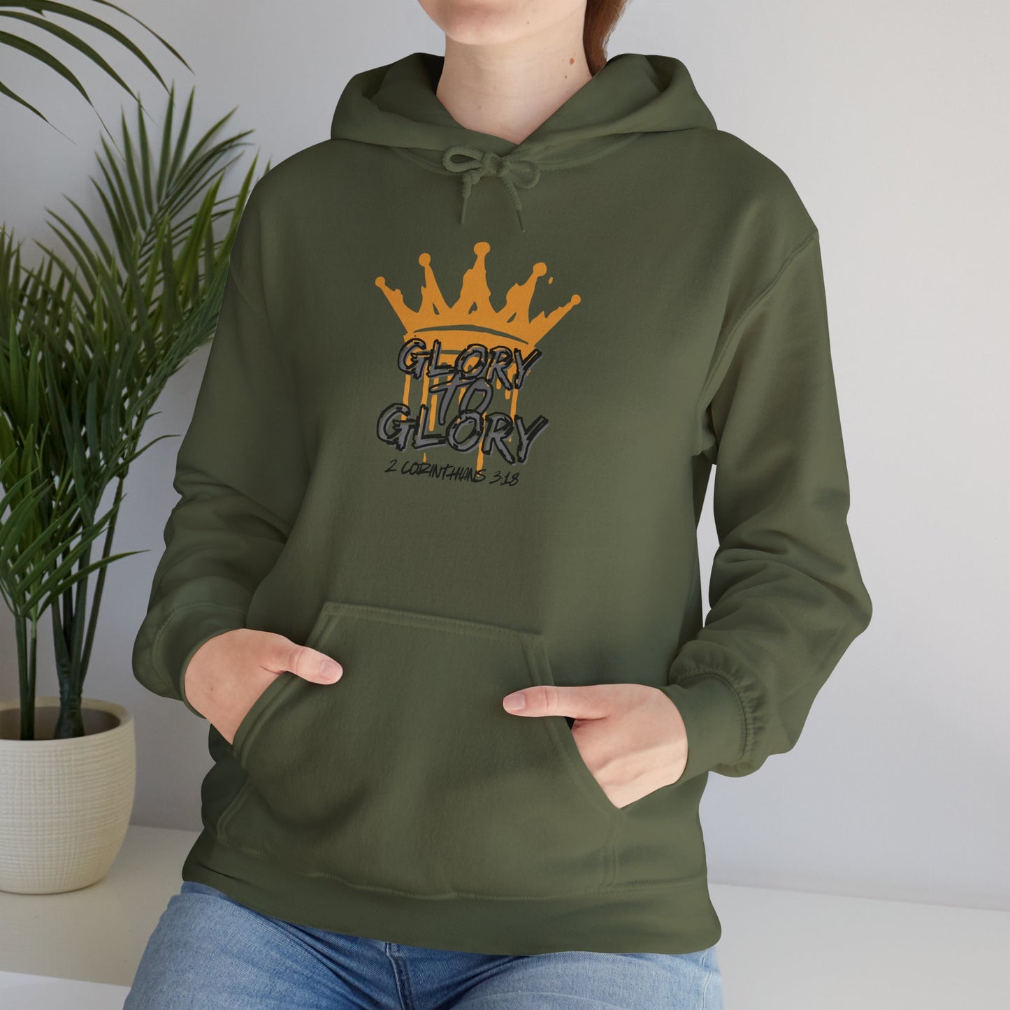 Olive green Glory to Glory hoodie with crown graphic and front pocket worn by a woman