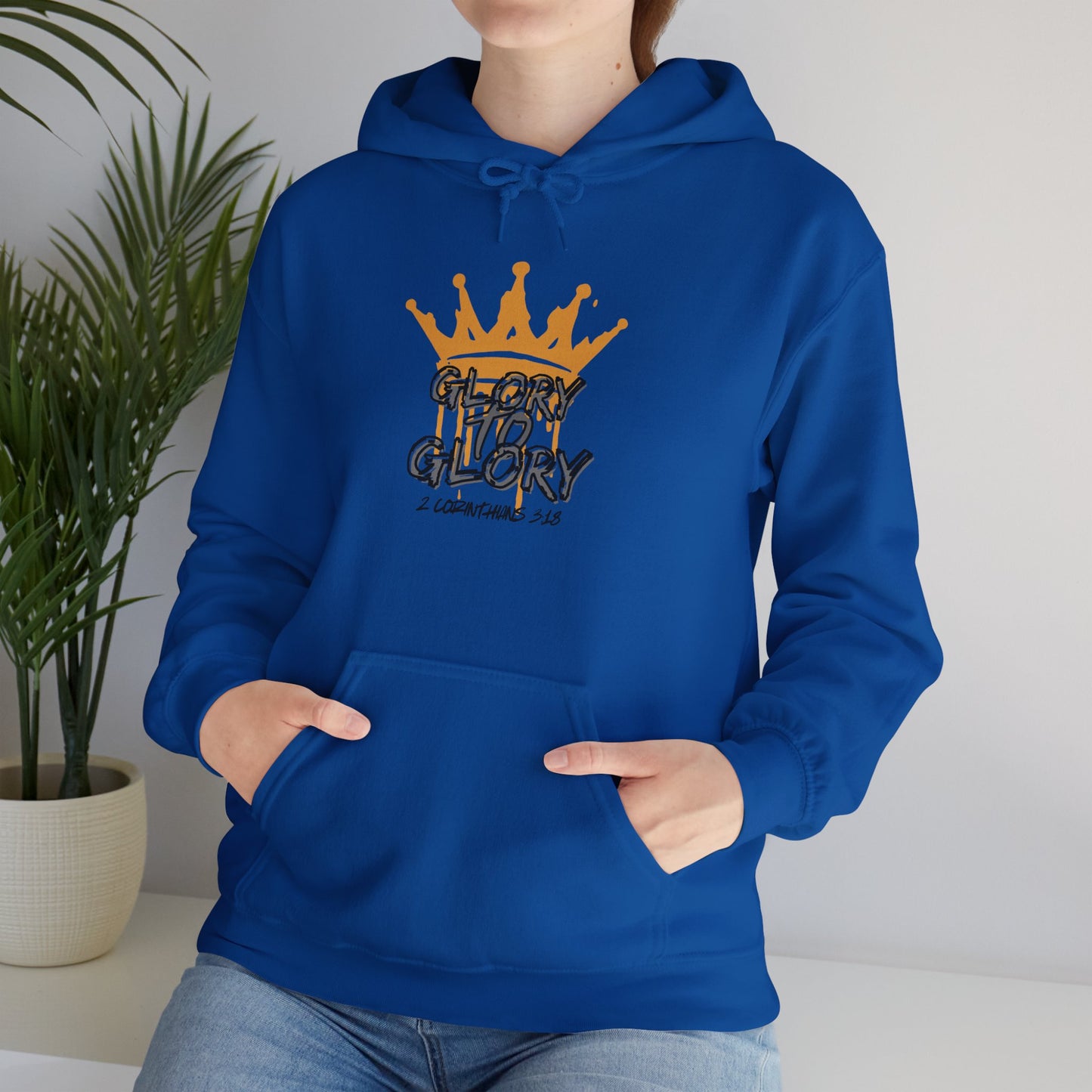 Blue Glory to Glory hoodie with orange crown graphic worn by person sitting indoors