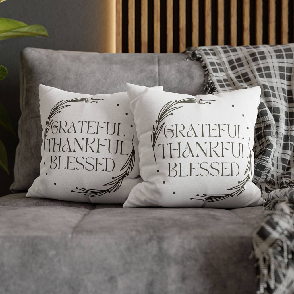 Two decorative pillows on a gray sofa featuring the Grateful Thankful Blessed pillowcase in an elegant design