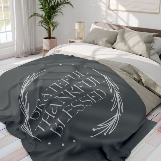 Cozy Grateful Thankful Blessed throw blanket on a bed with neutral bedding and soft textures