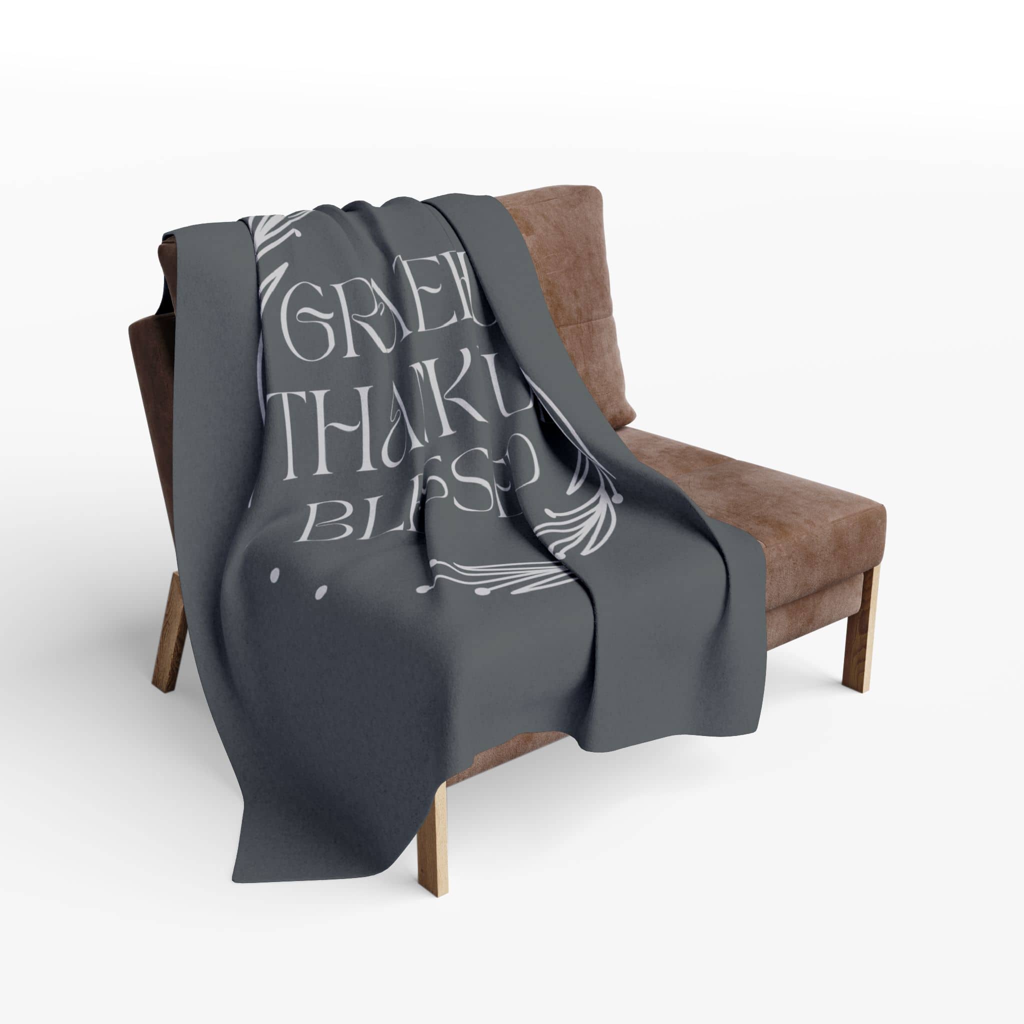 Cozy Grateful Thankful Blessed throw blanket draped over a modern armchair in gray