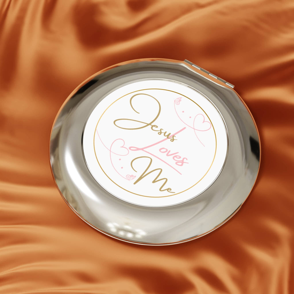 Jesus Loves Me compact mirror with elegant design on a soft fabric background