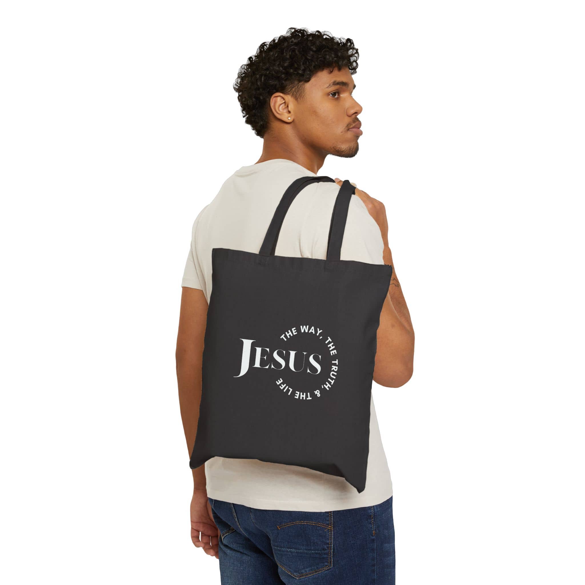 Canvas tote bag featuring 'Jesus The Way, The Truth, The Life' in white on a black background, back view