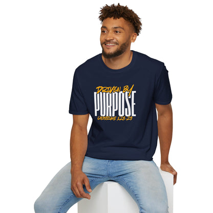 Man wearing navy Driven by Purpose shirt with bold white and yellow text sitting on white block