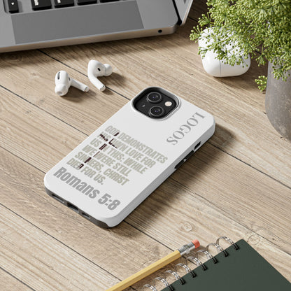 Logos Co. faith-based tough cases with Romans 5:8 Bible verse design on white phone case on wooden desk