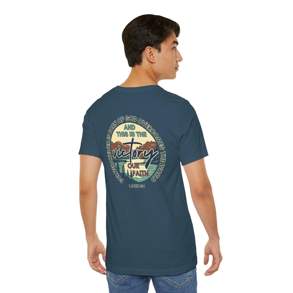Back view of a man wearing a blue This Is The Victory T-shirt with faith and victory graphic