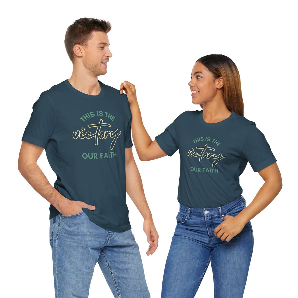 Two models wearing indigo blue Logos Co. - This Is The Victory T-shirt with faith-themed typography design