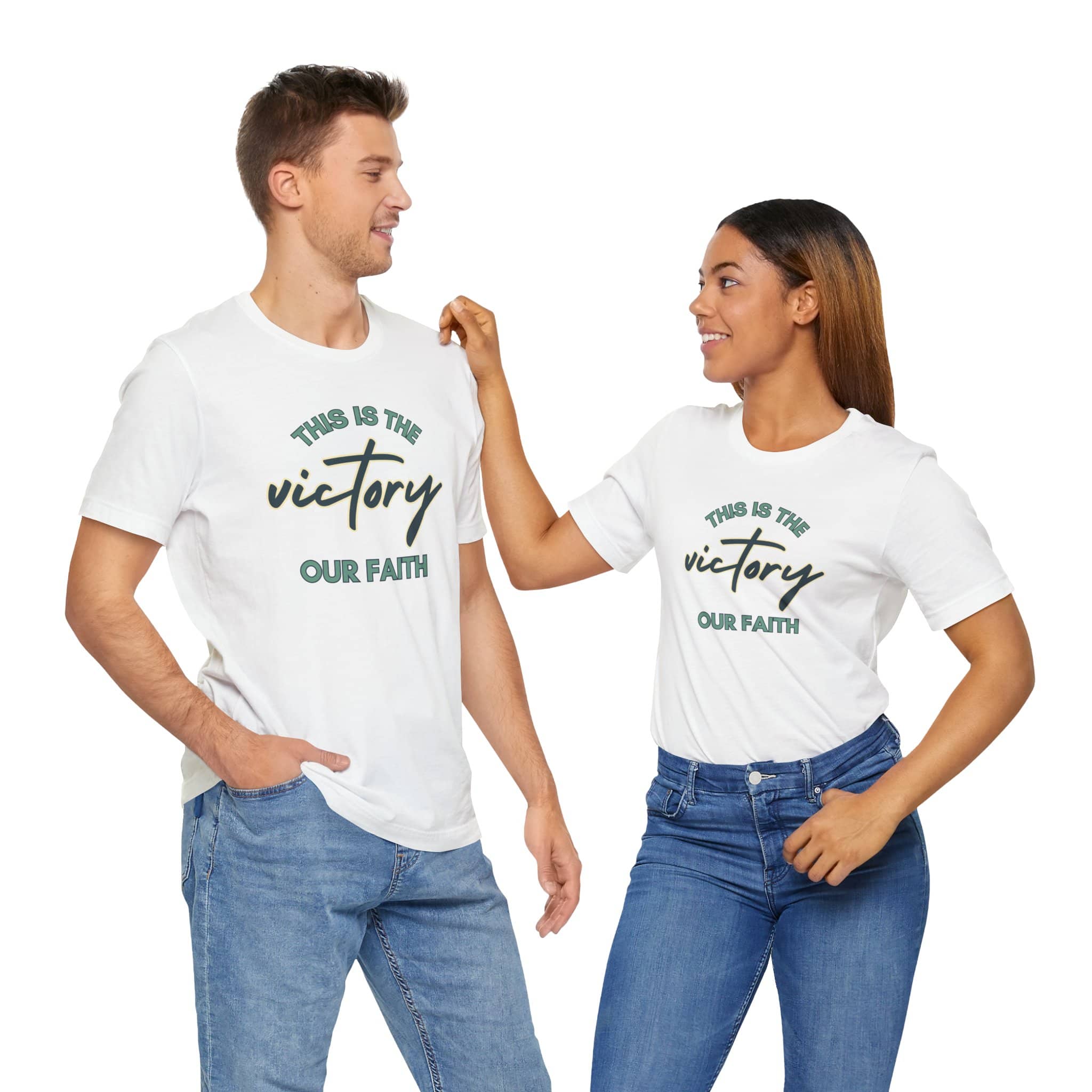 Man and woman wearing white This Is The Victory T-shirt with faith message and casual jeans