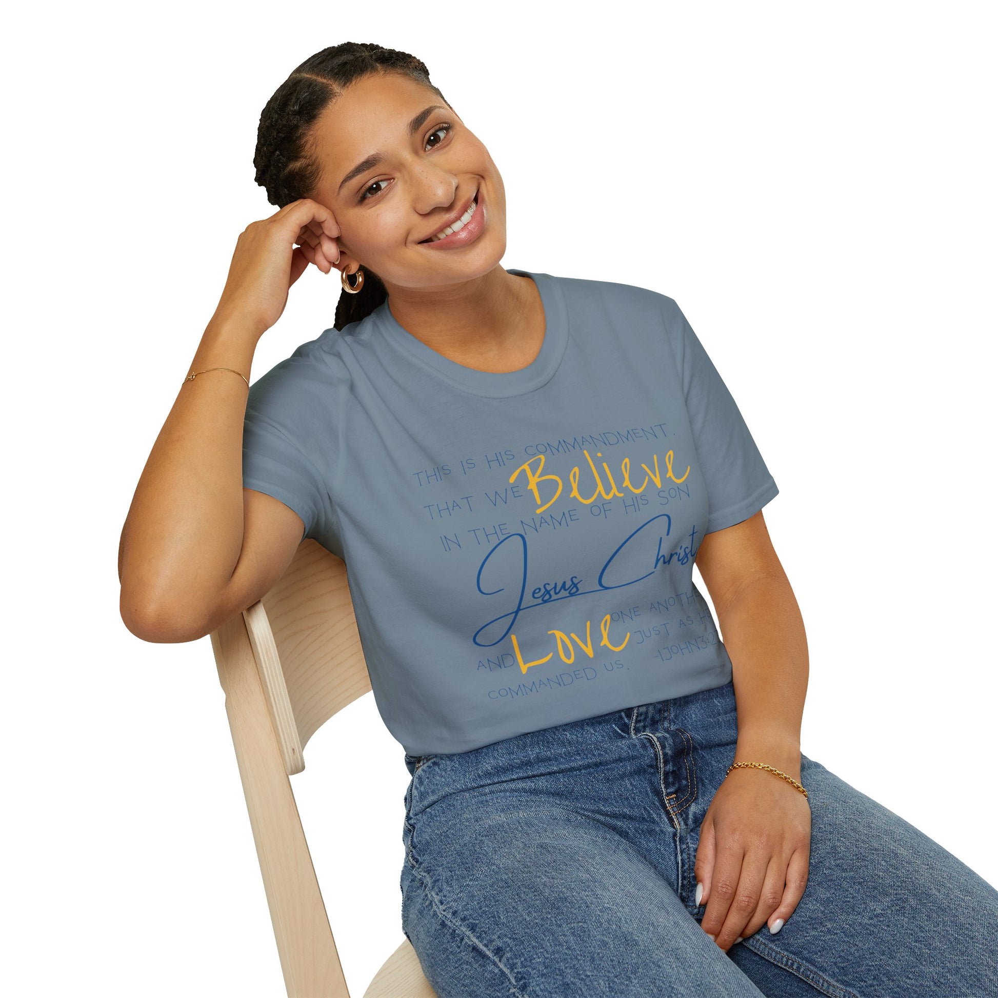 Logos Love One Another shirt in blue with inspirational text worn by a smiling woman seated on a chair