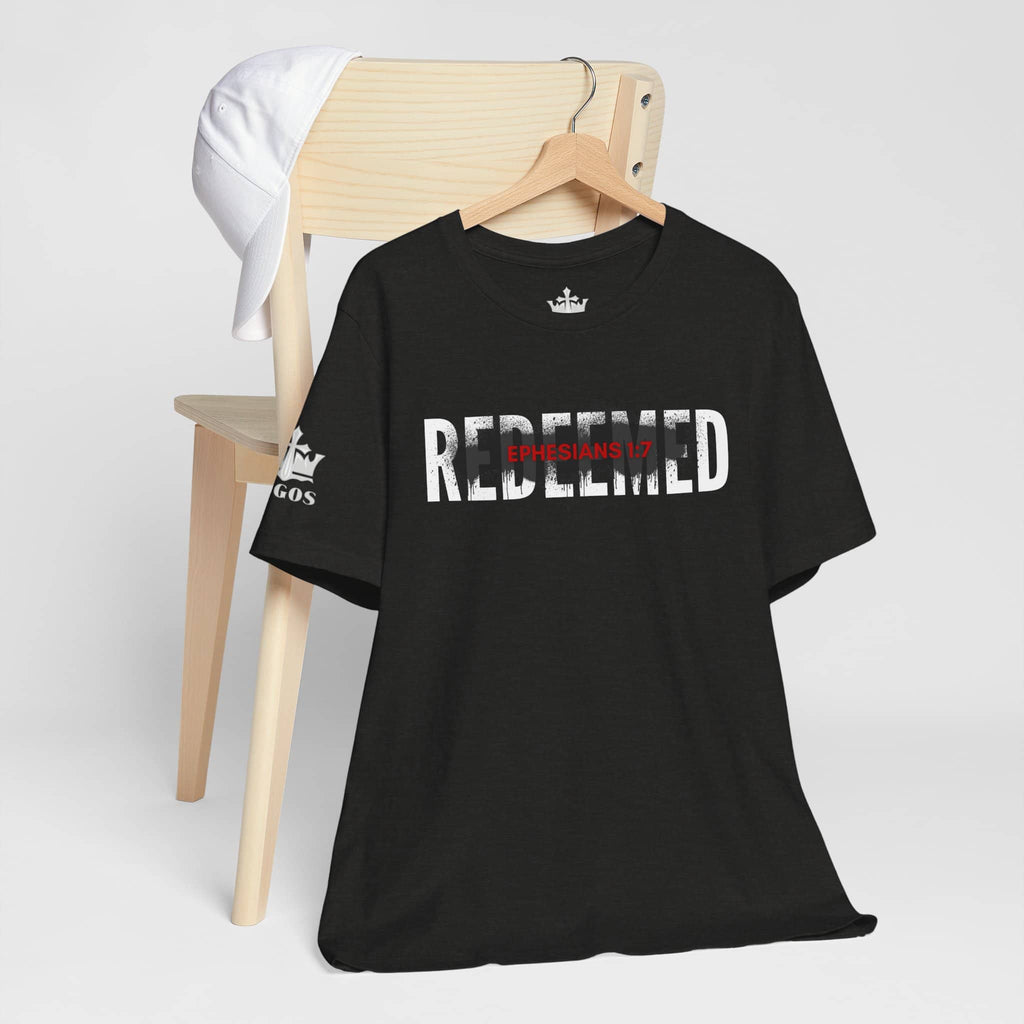 Black Redeemed t-shirt featuring Ephesians 1:7 design on a wooden chair