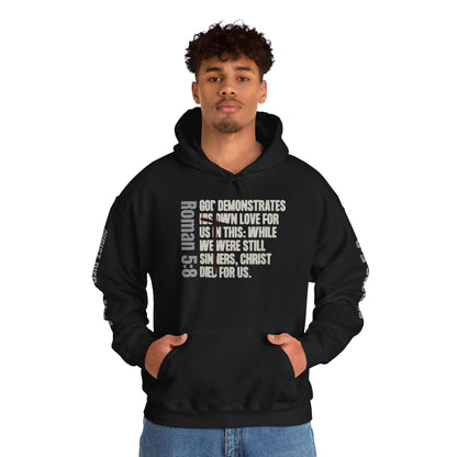 Black Romans 5:8 hoodie from Logos featuring scripture text design worn by a male model
