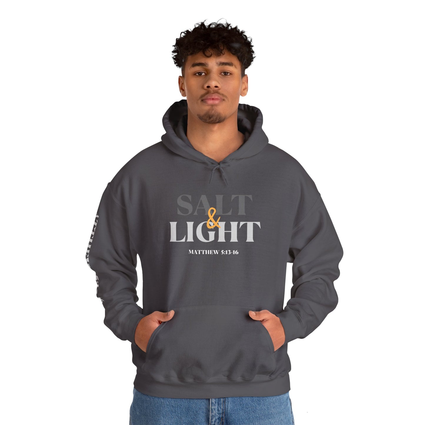 Salt and Light scripture hoodie featuring the front design in charcoal on a man with both hands in the kangaroo pocket